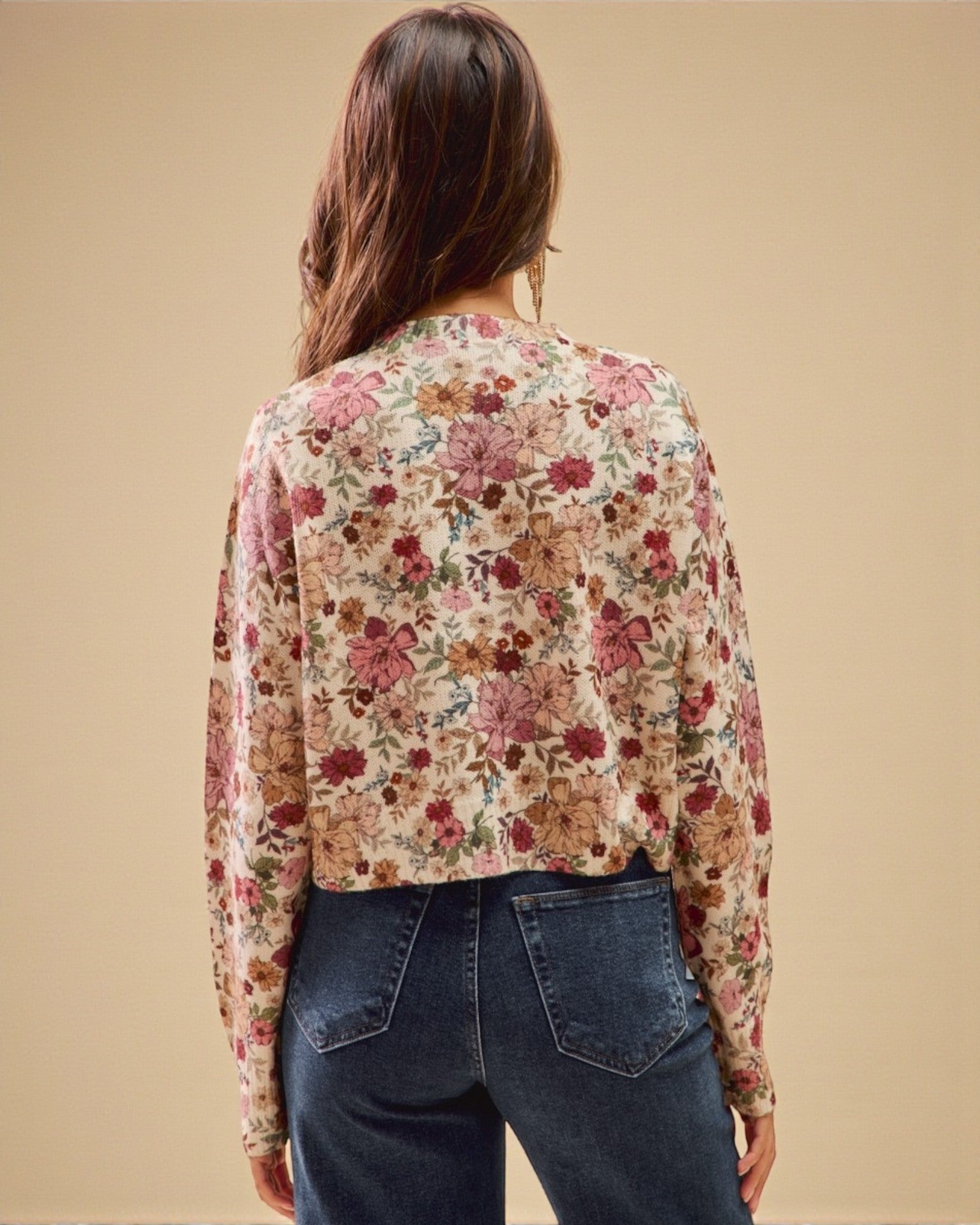 Person wearing a floral blouse with a beige background