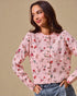 Woman wearing a pink floral blouse against a beige background