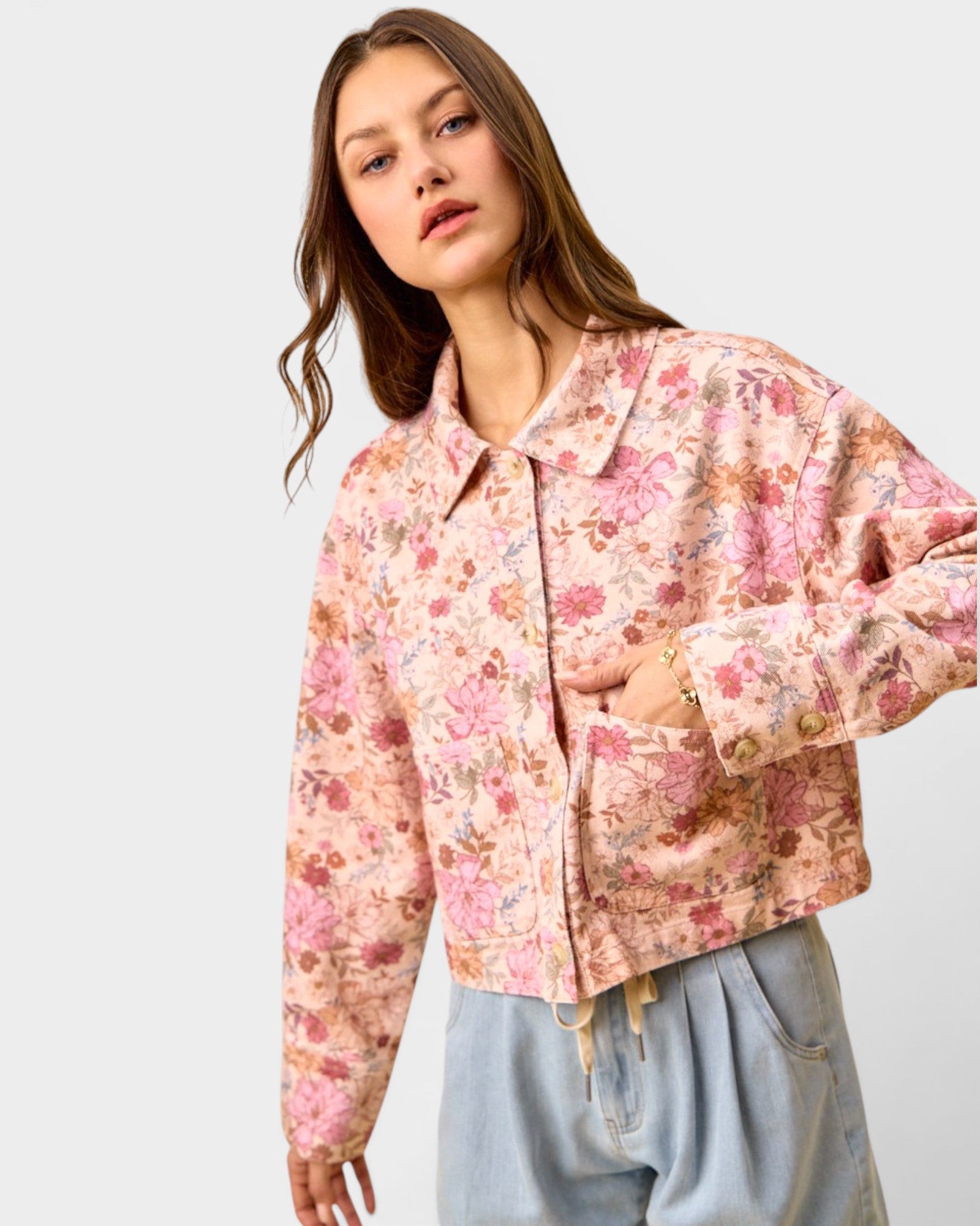 Woman wearing a floral jacket on a plain background