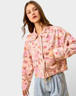 Woman wearing a floral jacket on a plain background