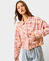 Woman wearing a floral jacket on a plain background