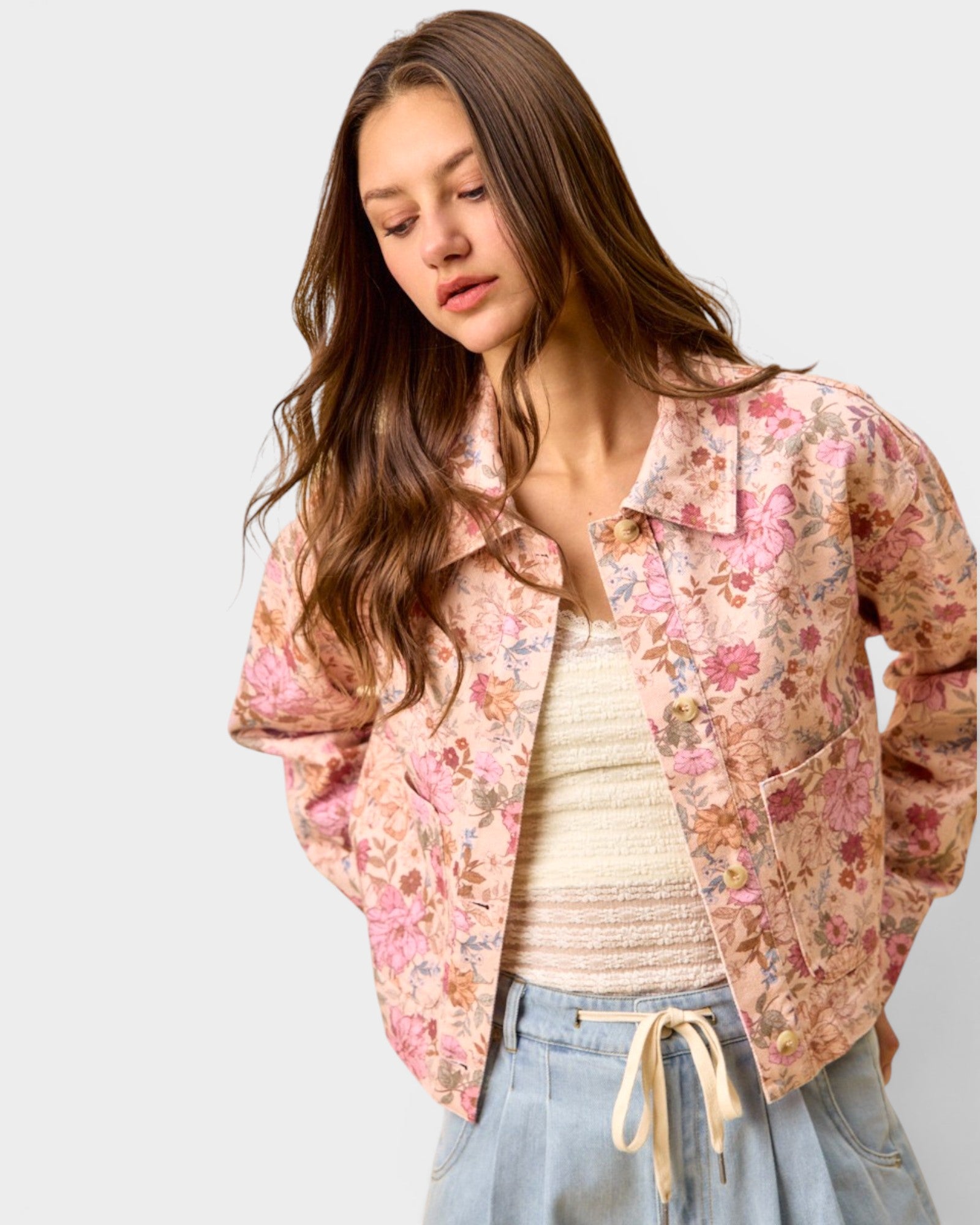 Woman wearing a floral jacket on a plain background