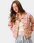 Woman wearing a floral jacket on a plain background