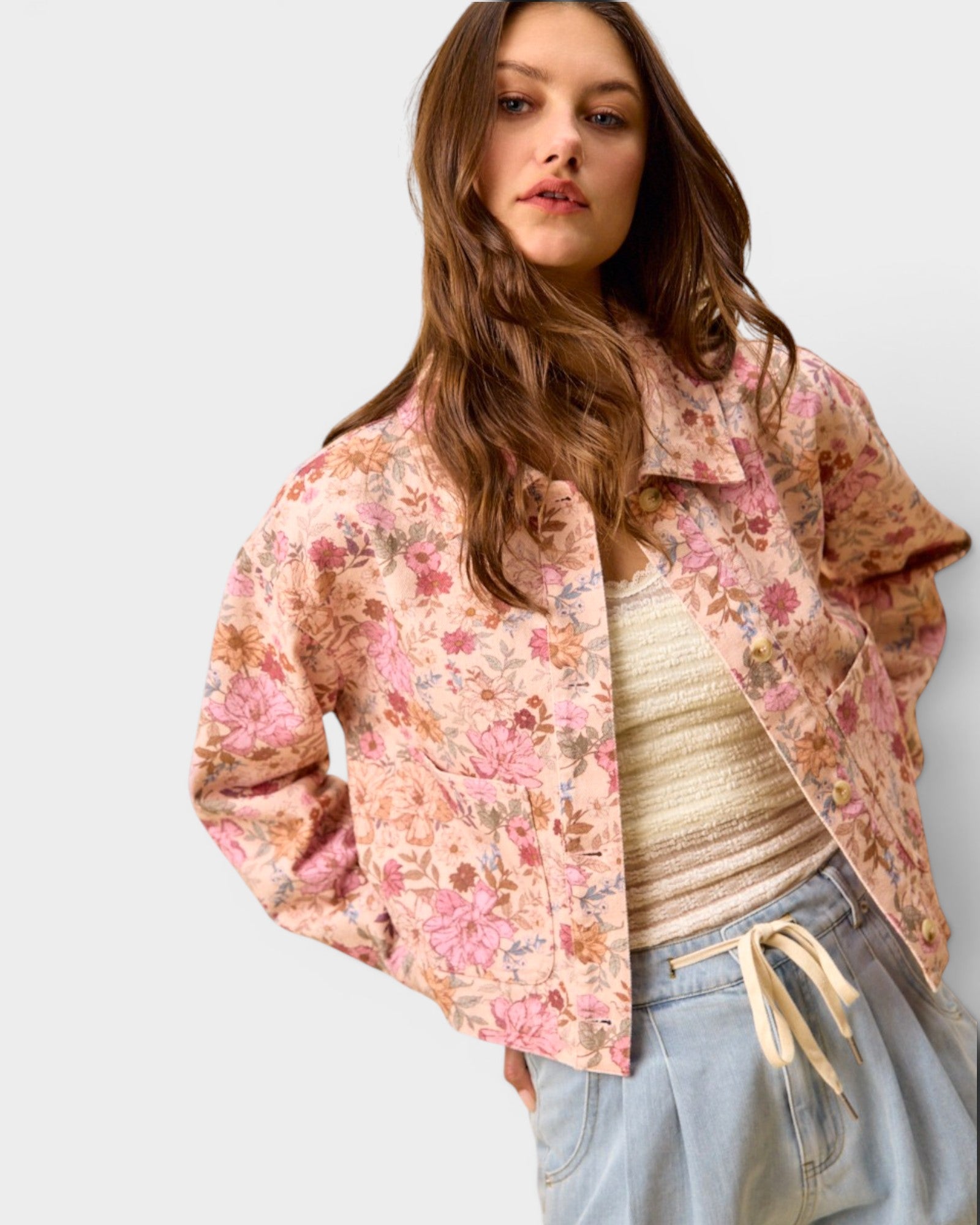 Woman wearing a floral jacket with a plain background