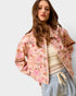 Woman wearing a floral jacket with a plain background
