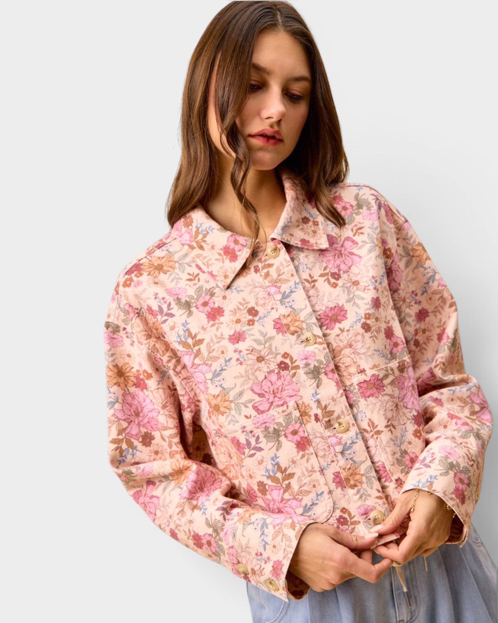 Woman wearing a floral patterned jacket on a plain background