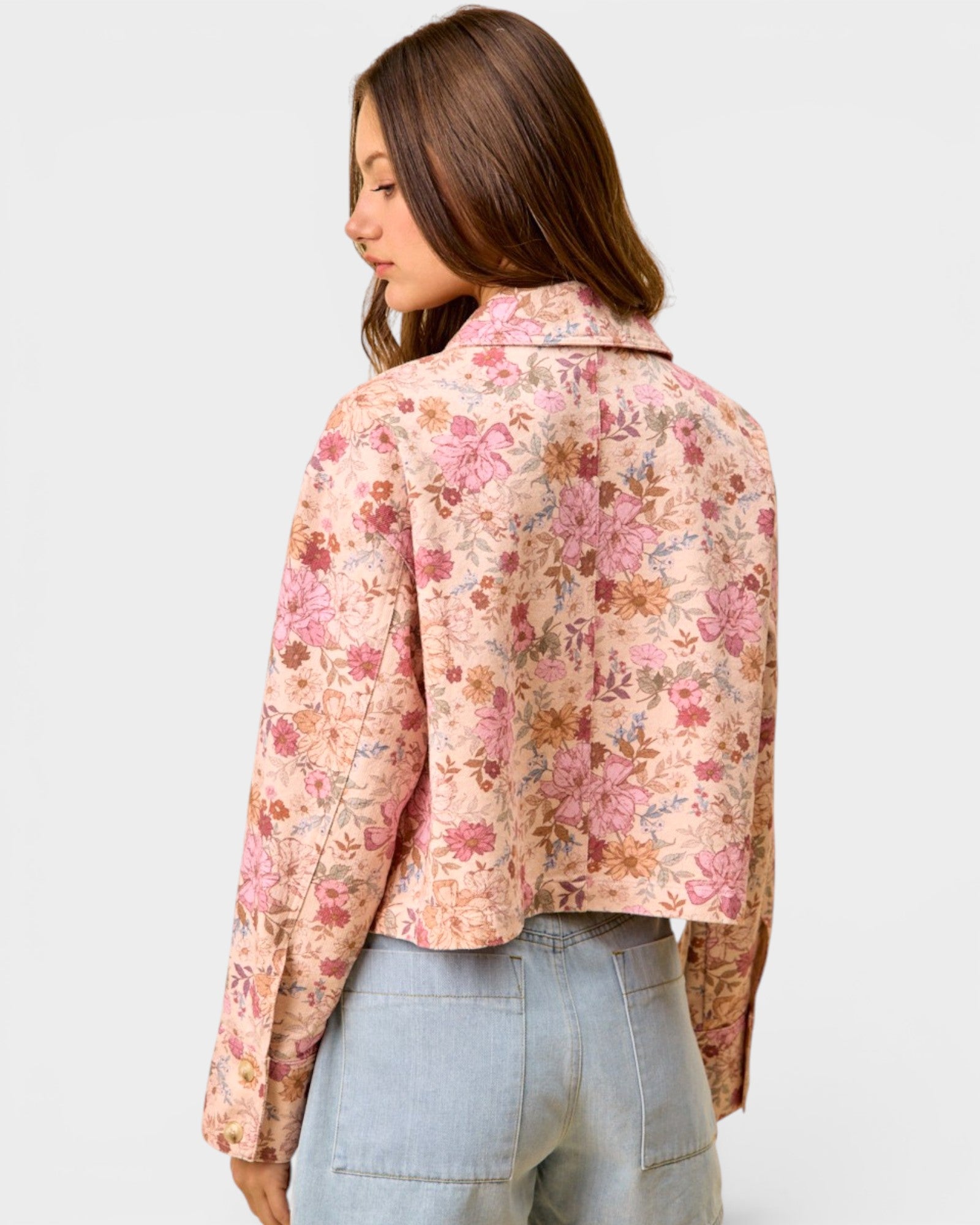 Woman wearing a floral blouse with a plain background