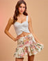 Woman wearing a white top and floral skirt on a beige background