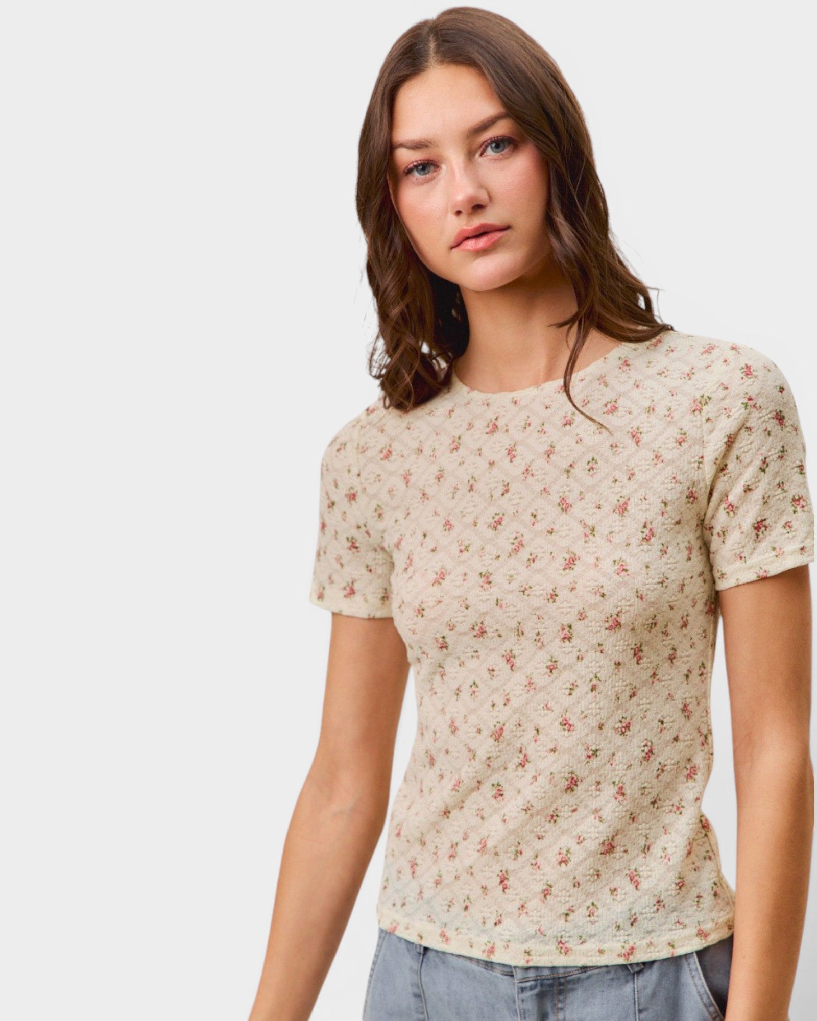 Woman wearing a floral patterned shirt against a plain background