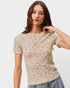 Woman wearing a floral patterned t-shirt against a plain background