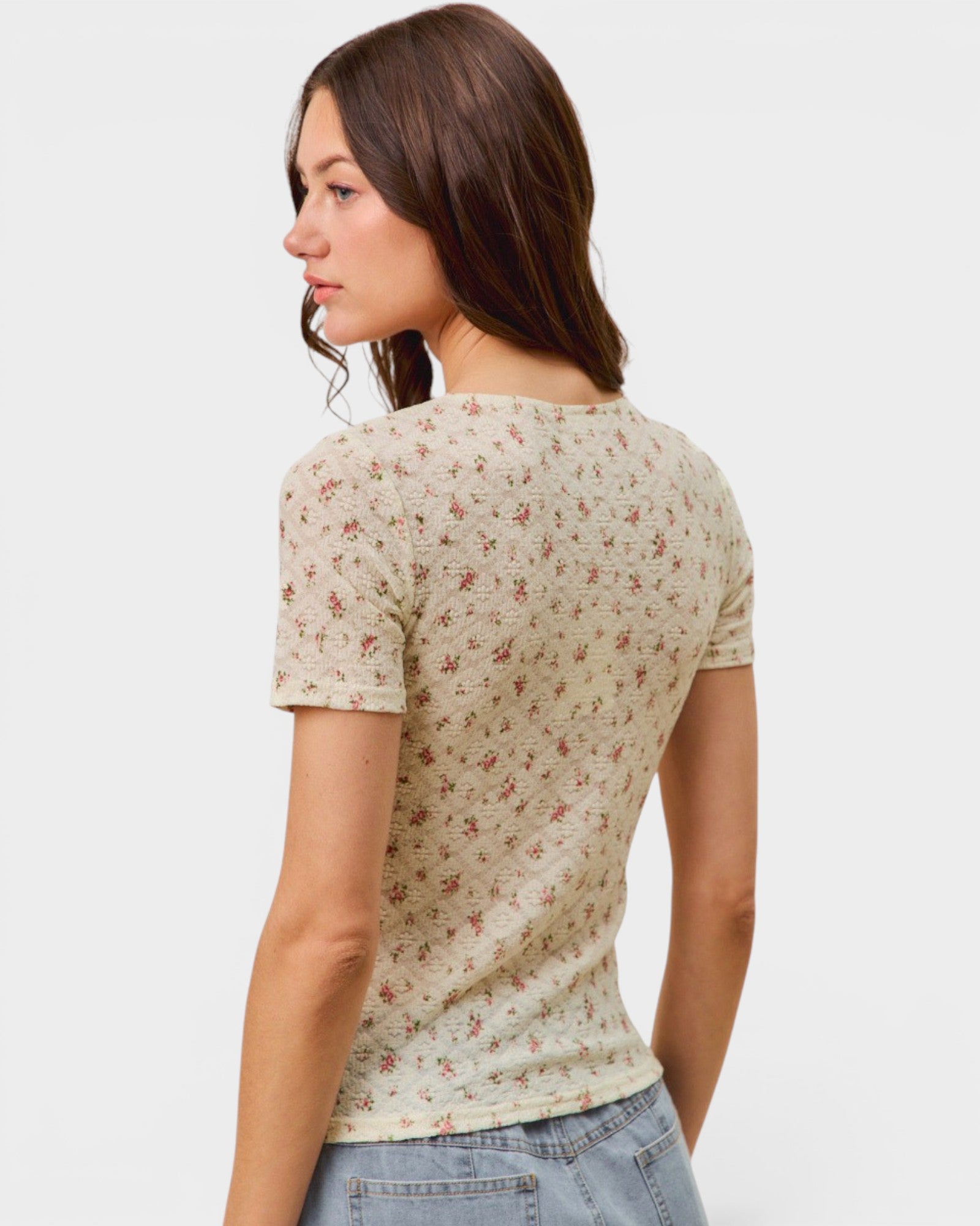 Woman wearing a floral patterned shirt on a plain background