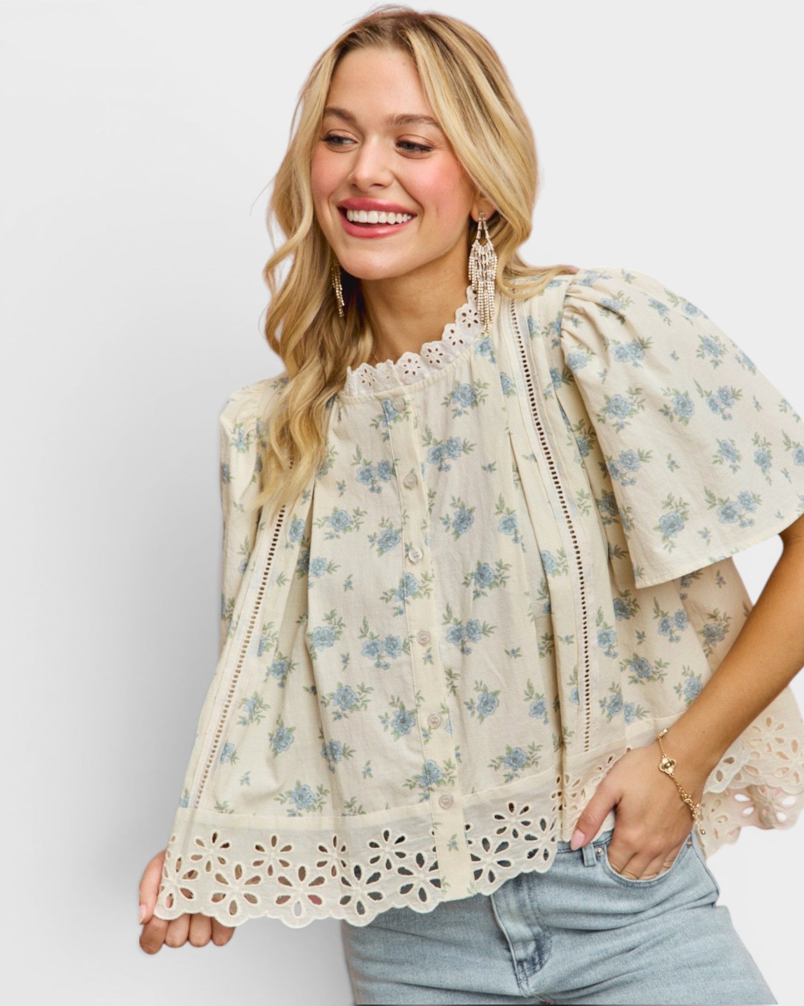 Woman wearing a floral blouse with lace details on a white background