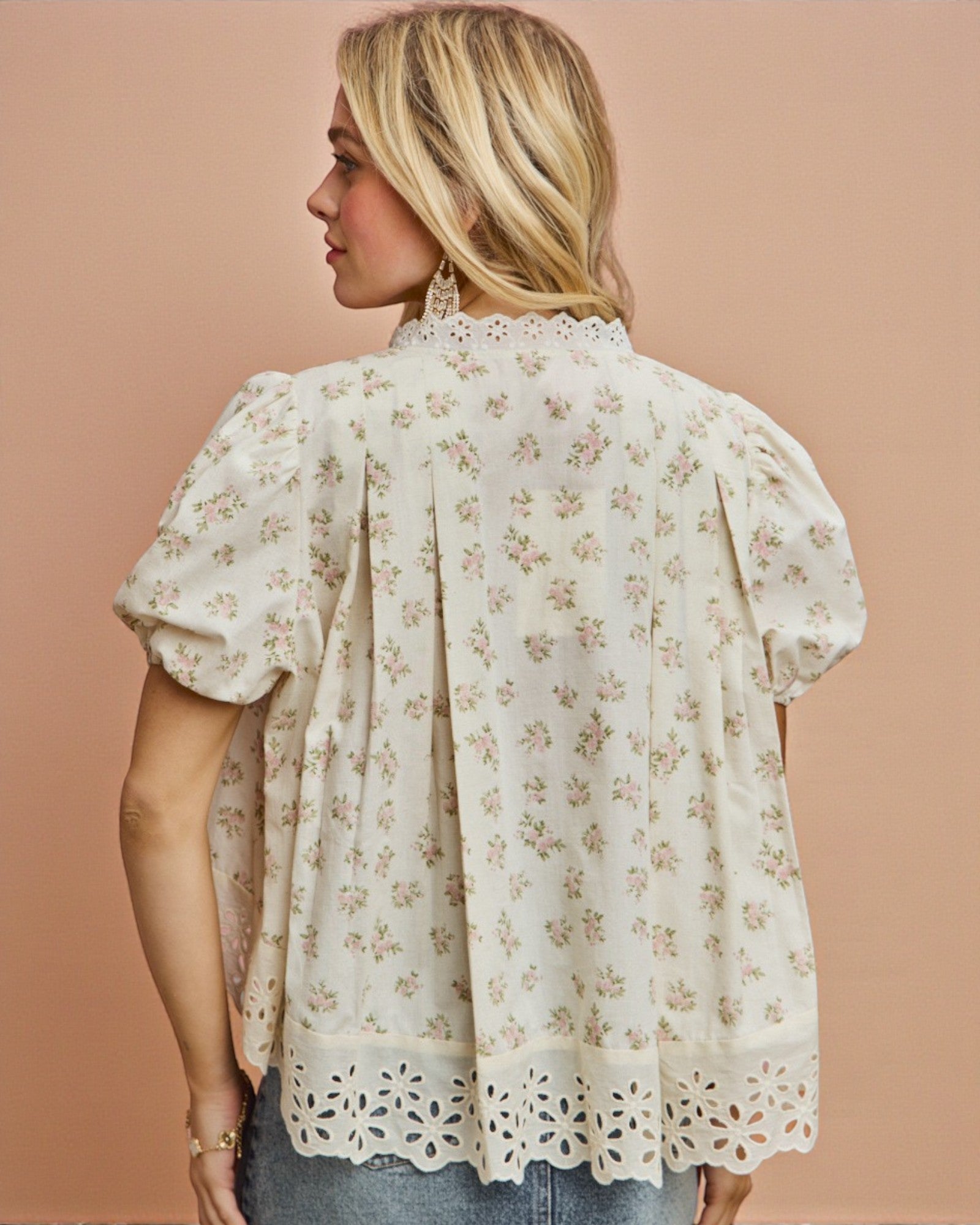 Woman wearing a floral blouse against a beige background