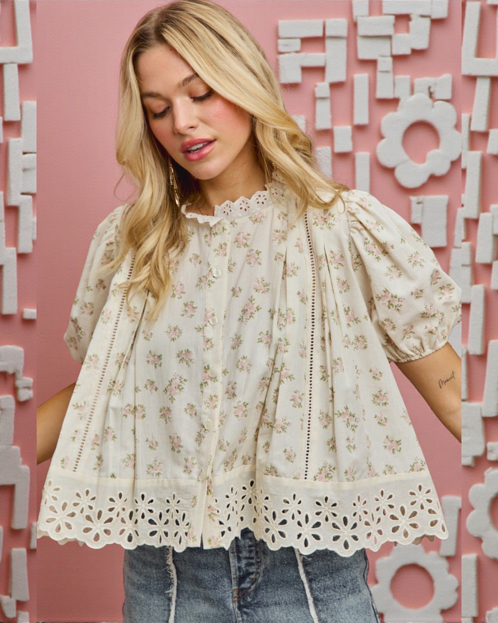 Woman wearing a floral blouse with a pink textured wall background