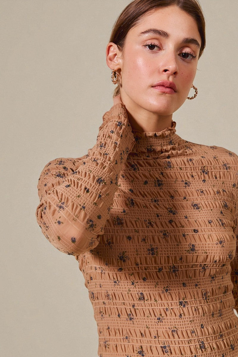 Woman wearing a brown patterned sweater against a beige background