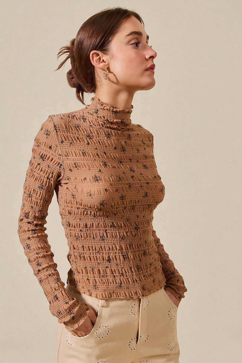 Woman wearing a brown textured sweater against a beige background