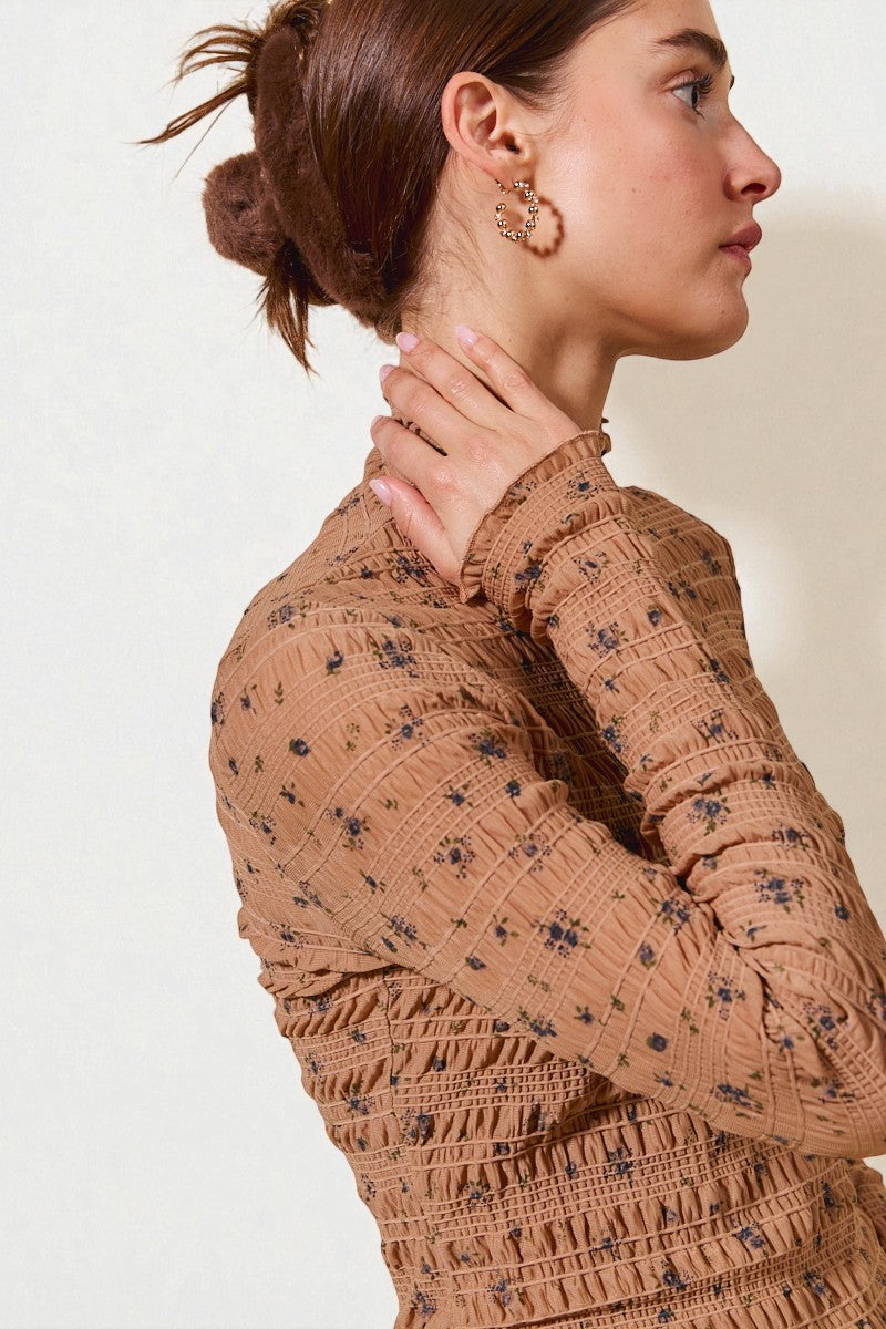 Woman wearing a brown patterned dress with a plain background