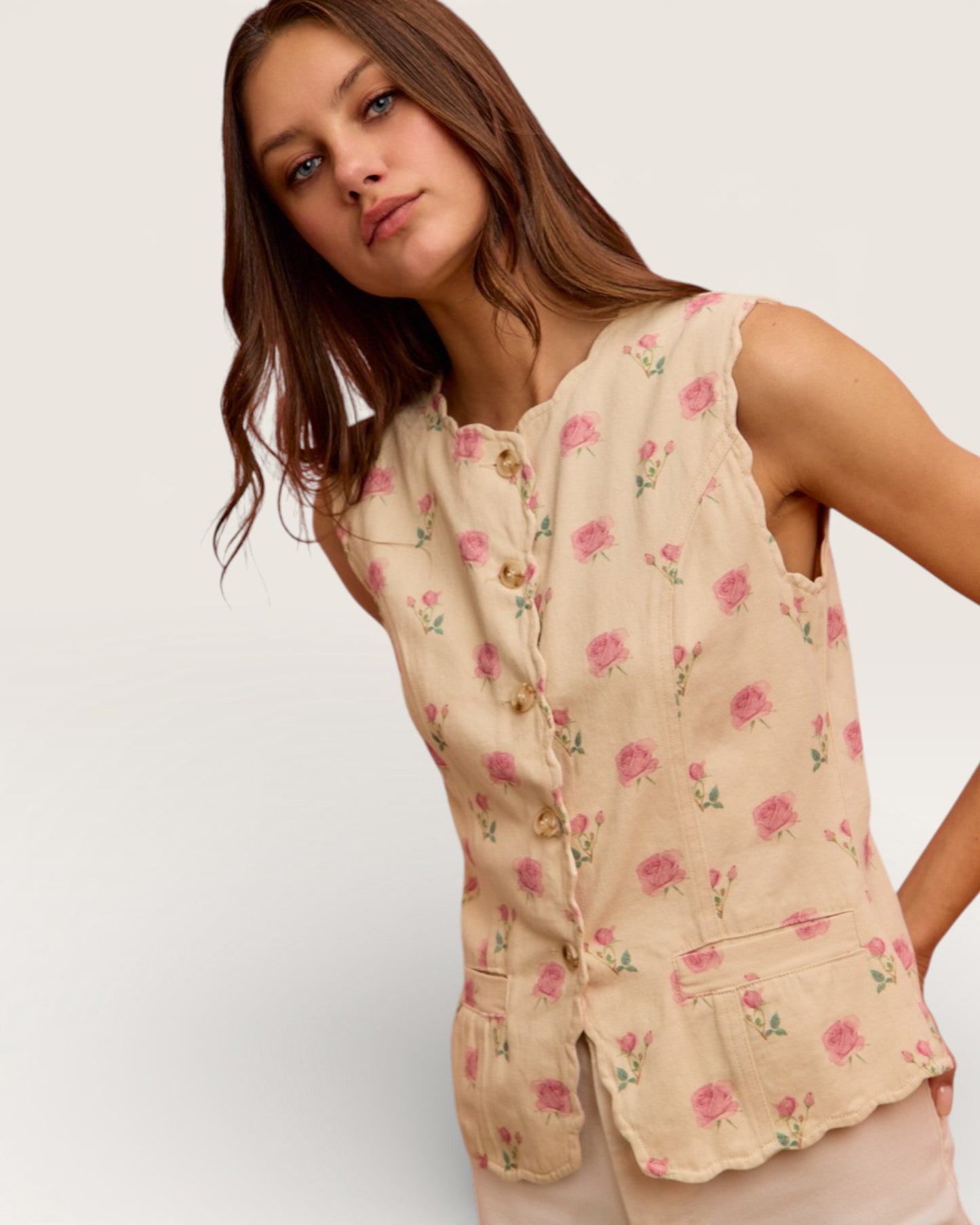 Woman wearing a floral sleeveless top on a plain background