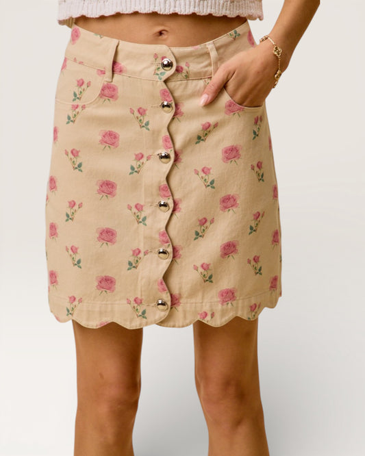 Beige skirt with floral pattern and button details on a plain background