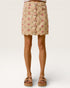 Beige skirt with floral pattern worn by a person on a white background