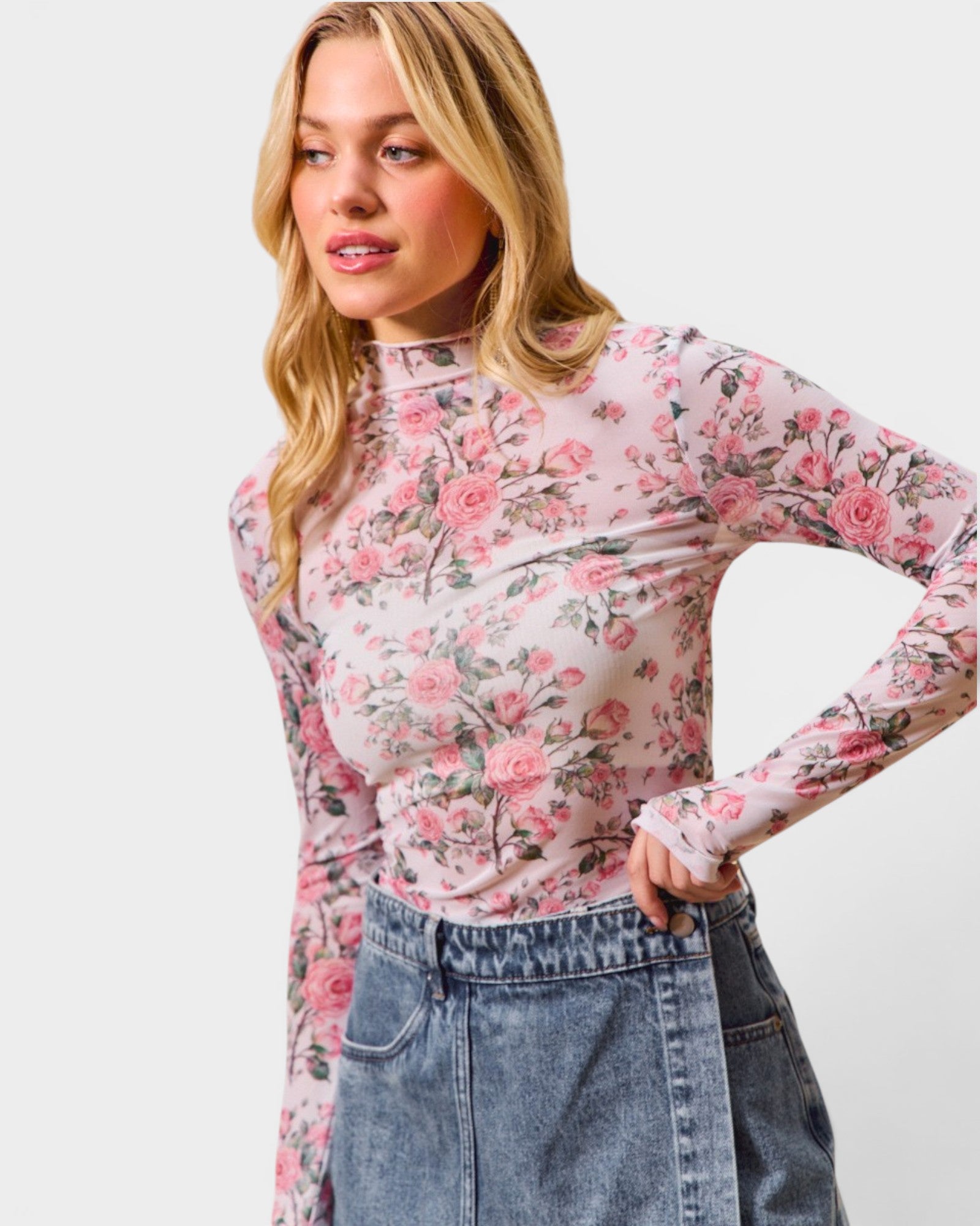 Woman wearing a floral long-sleeve top and jeans on a white background