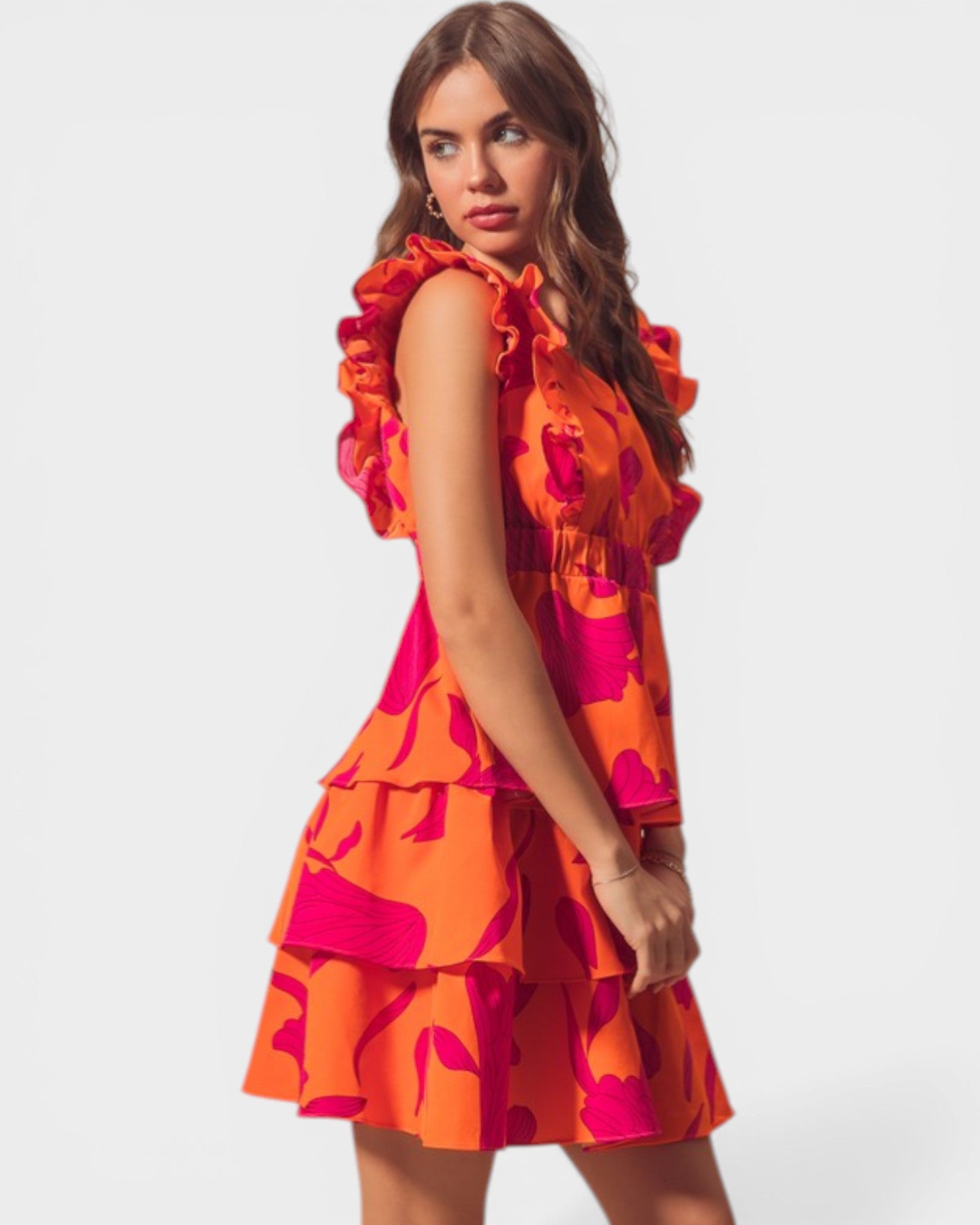 Woman wearing a colorful dress with ruffled layers on a white background