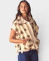 Woman wearing a beige floral-patterned cardigan on a white background