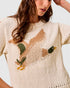 Beige sweater with a fox design worn by a person against a light background