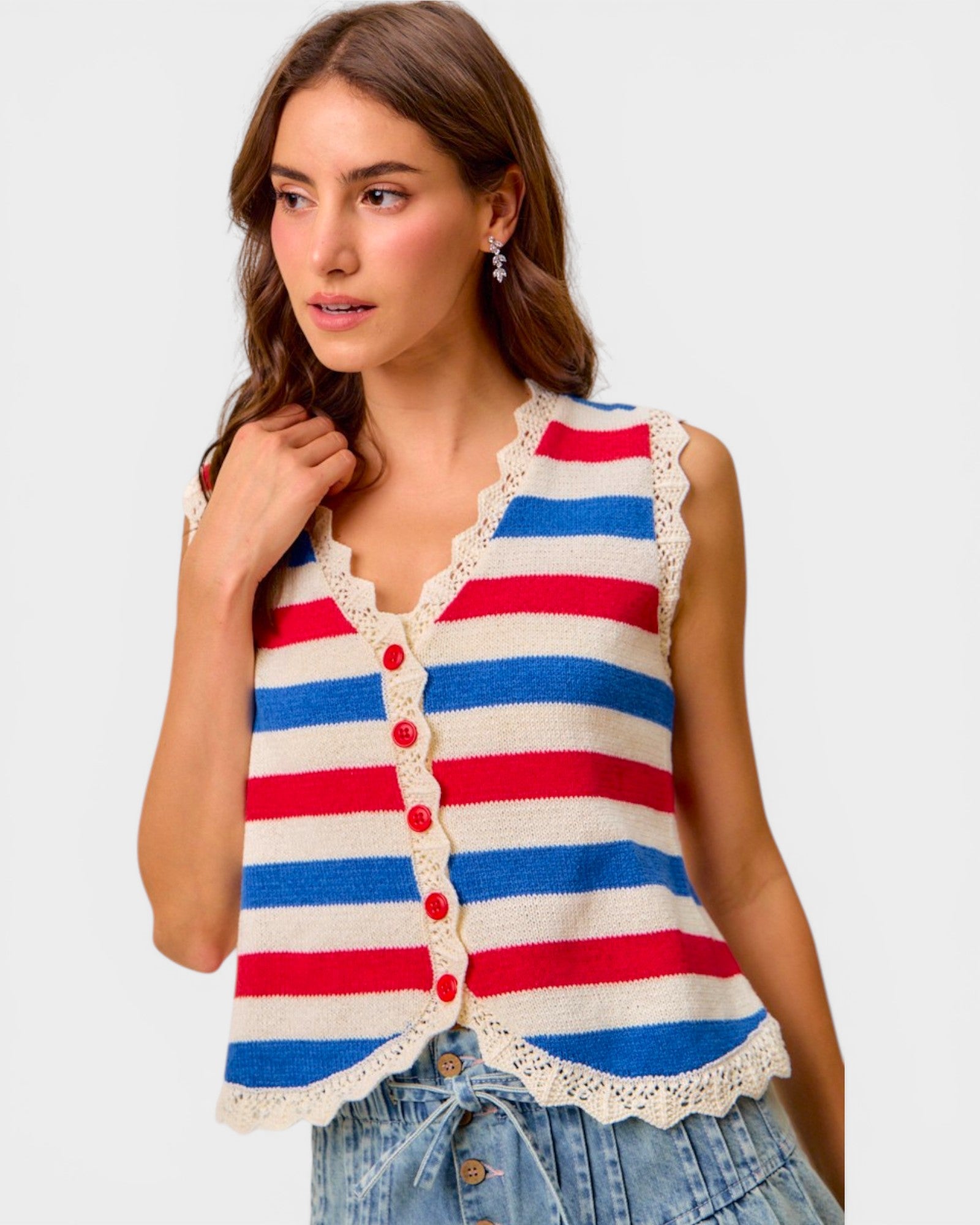 Woman wearing a red, white, and blue striped sleeveless top with lace trim on a plain background