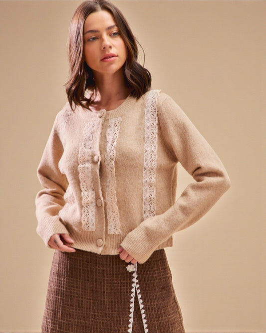 Woman wearing a beige sweater with lace details on a beige background