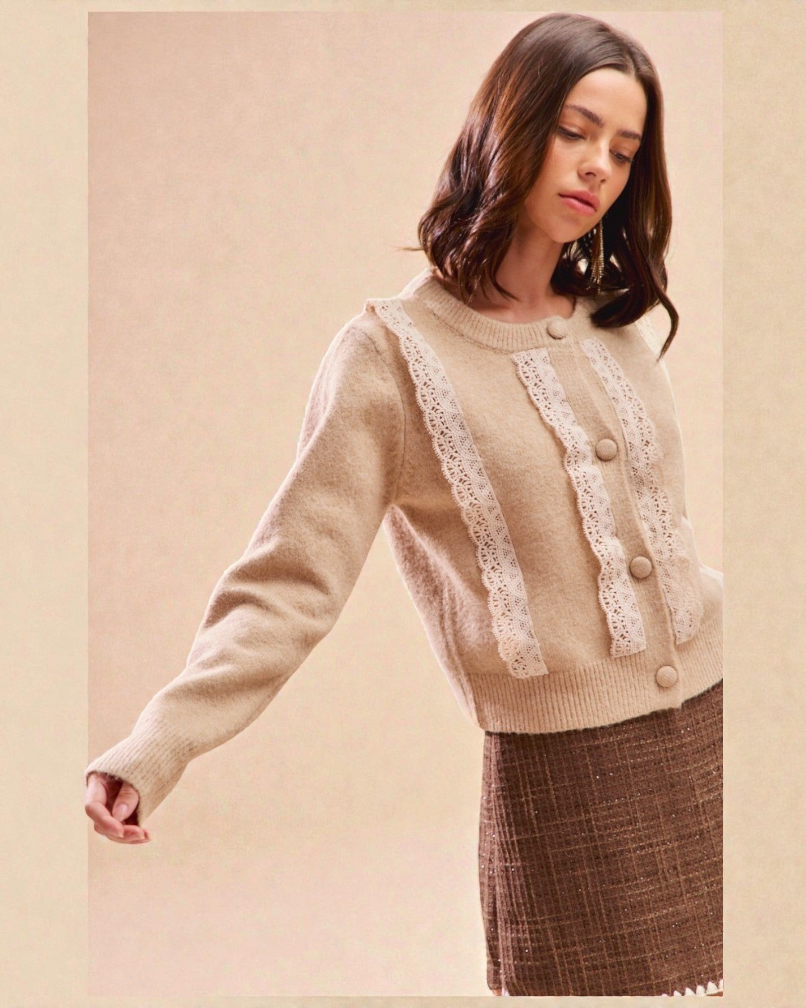 Woman wearing a beige sweater with lace details on a beige background