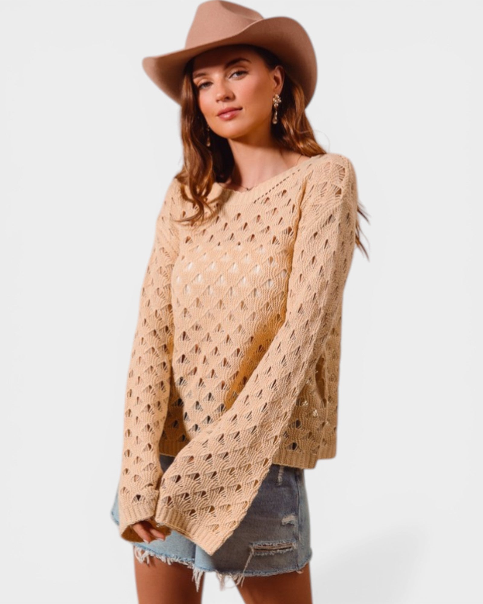 Woman wearing a beige knitted sweater and brown hat on a white background