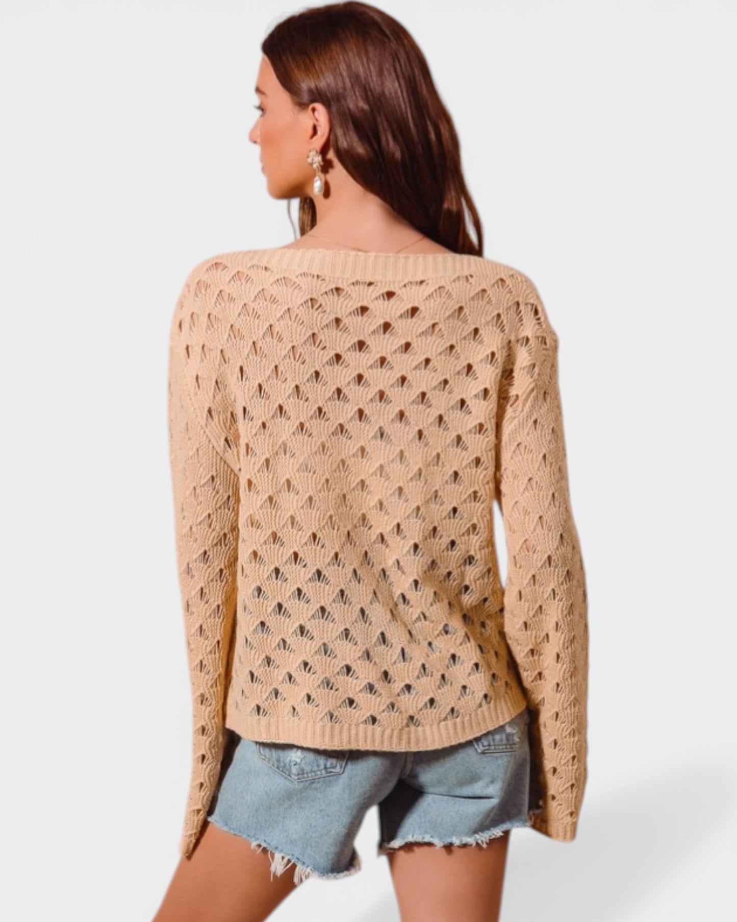 Woman wearing a beige knitted sweater with a white background