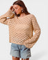 Woman wearing a beige open-knit sweater and denim shorts on a white background