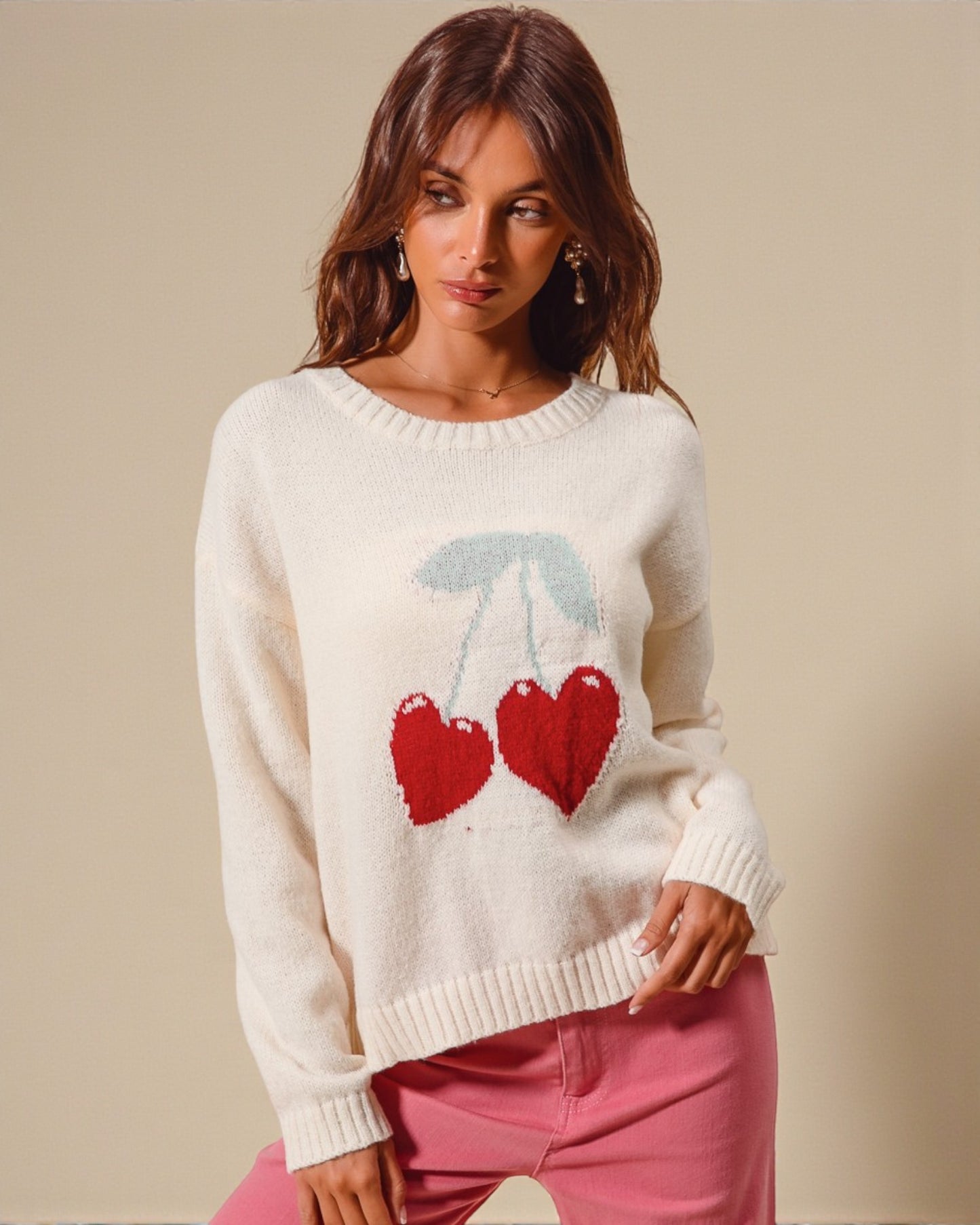 Woman wearing a cream sweater with heart design on a beige background