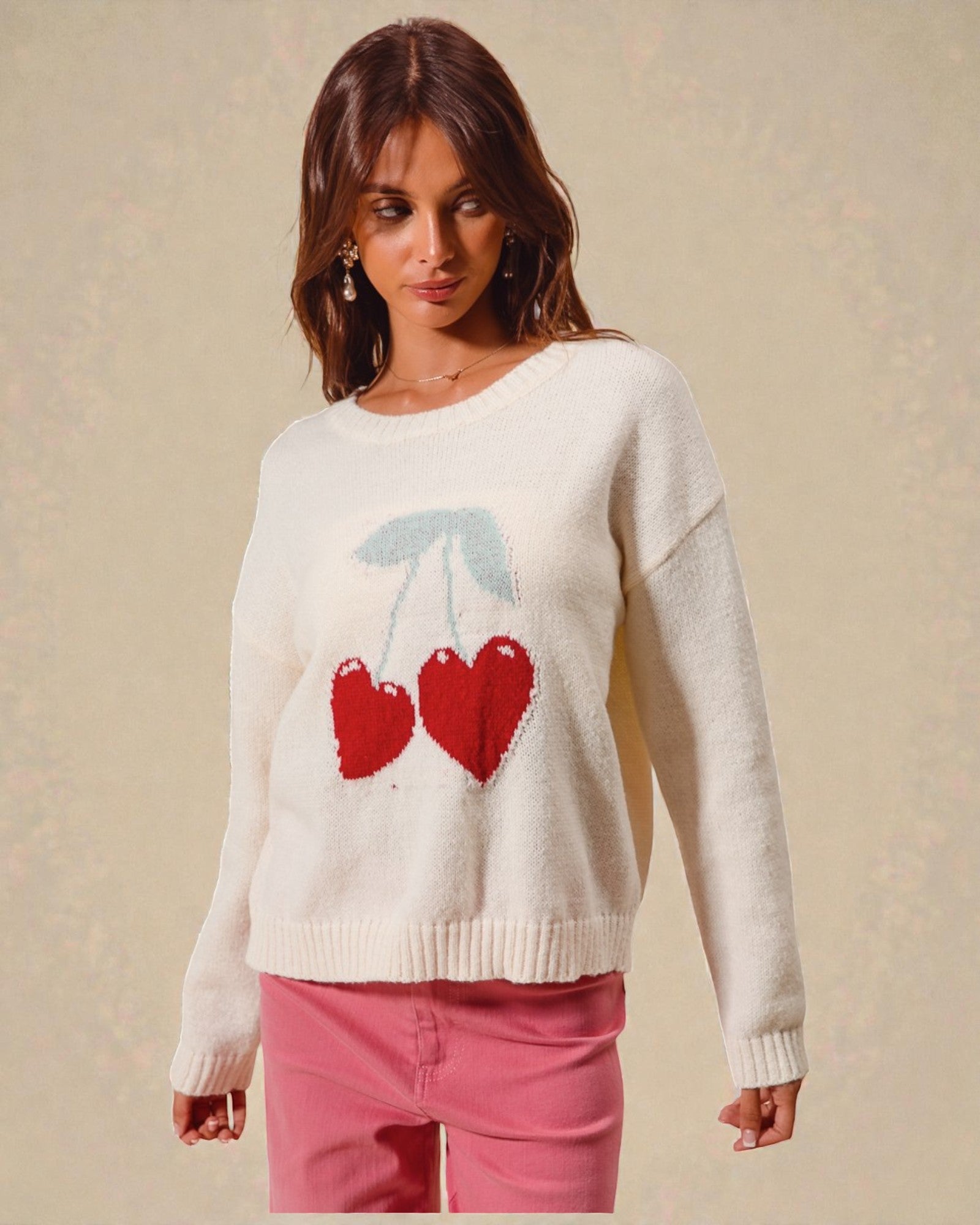 Woman wearing a cream sweater with red heart design on a beige background