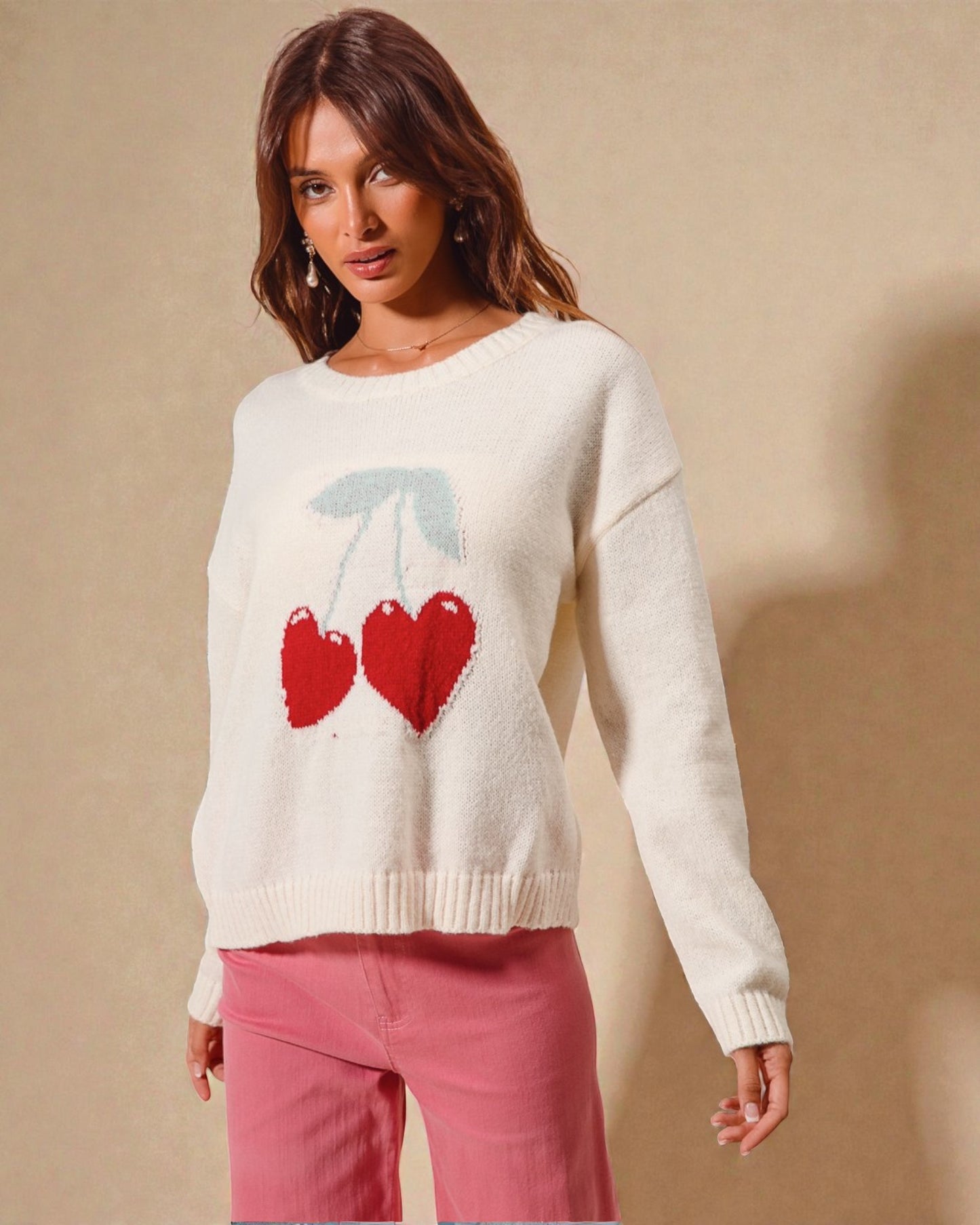Woman wearing a white sweater with red heart design on a beige background