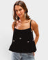 Woman wearing a black top with bow details on a white background