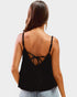 Black strappy top worn by a person on a white background