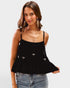 Woman wearing a black top with bow details on a white background