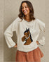 Woman wearing a sweater with a horse design against a neutral background