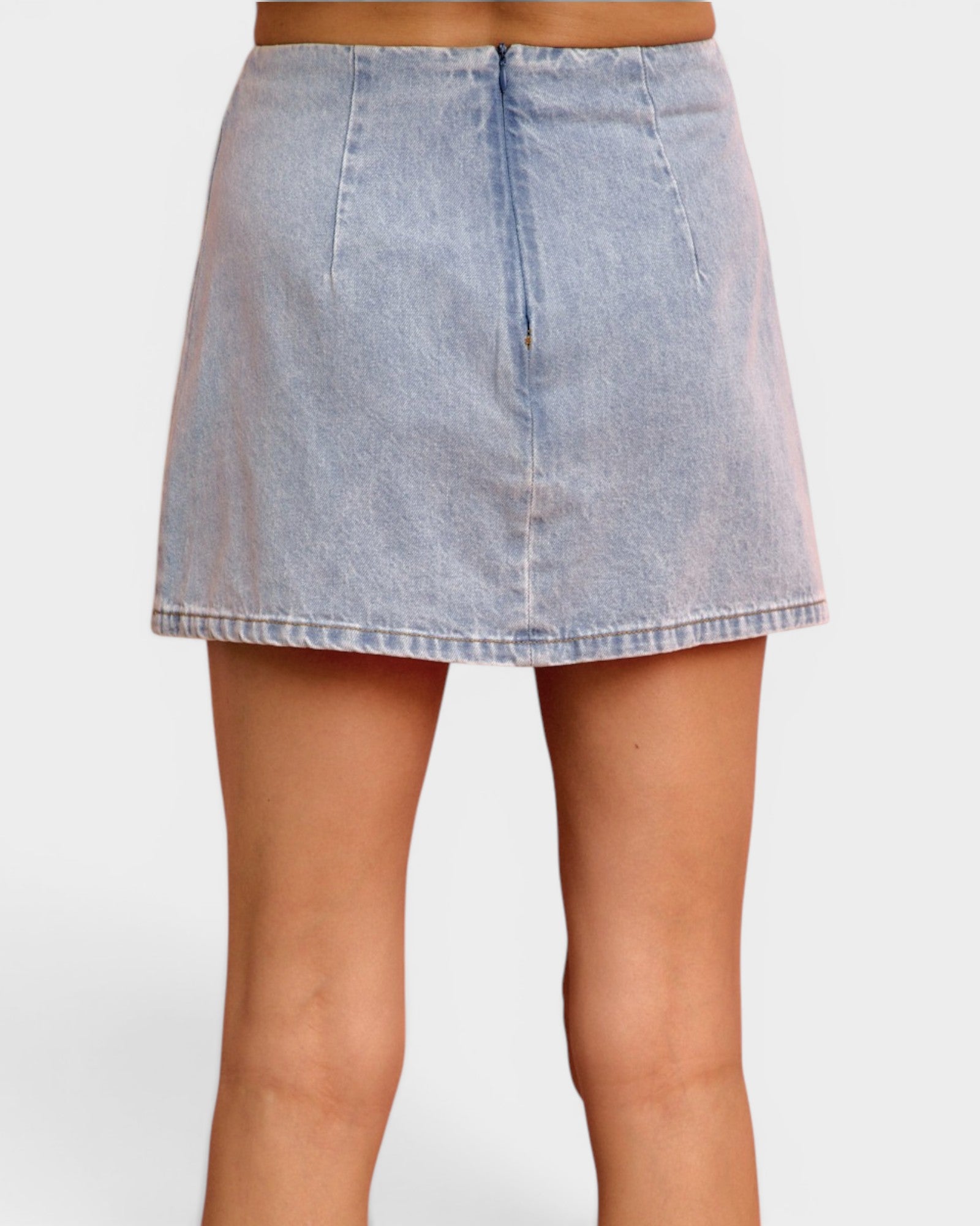 Denim skirt worn by a person on a white background