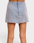 Denim skirt worn by a person on a white background