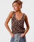 Woman wearing a leopard print tank top and jeans on a plain background