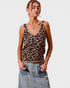 Woman wearing a leopard print tank top and denim skirt on a plain background