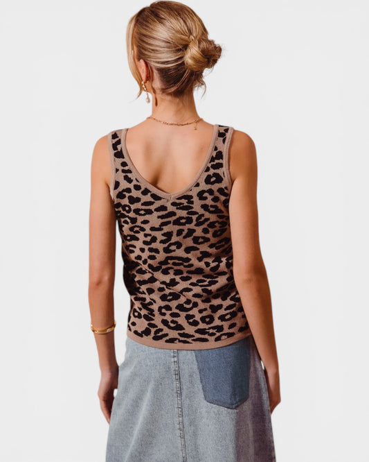 Person wearing a leopard print tank top on a plain background