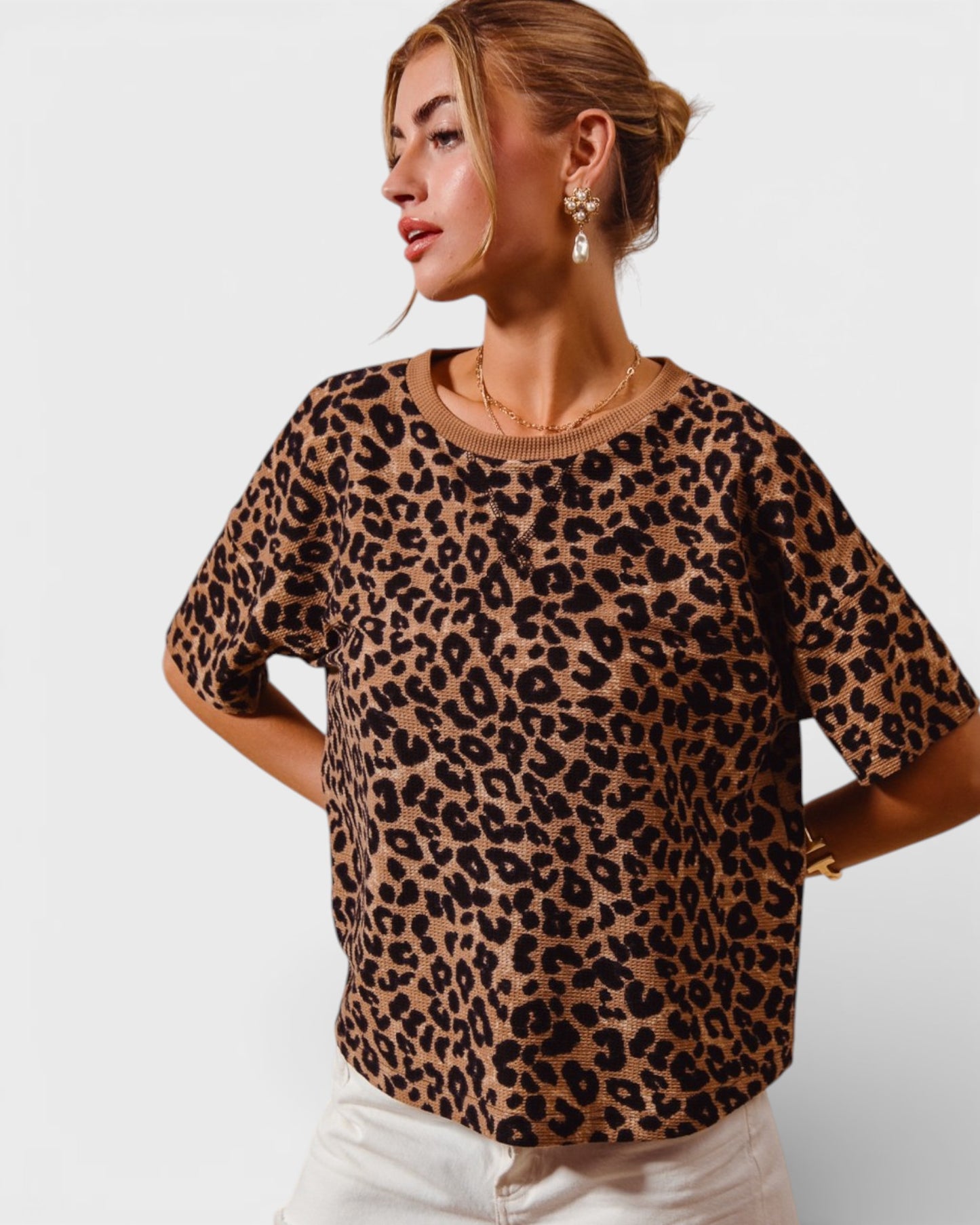 Woman wearing a leopard print top against a plain background