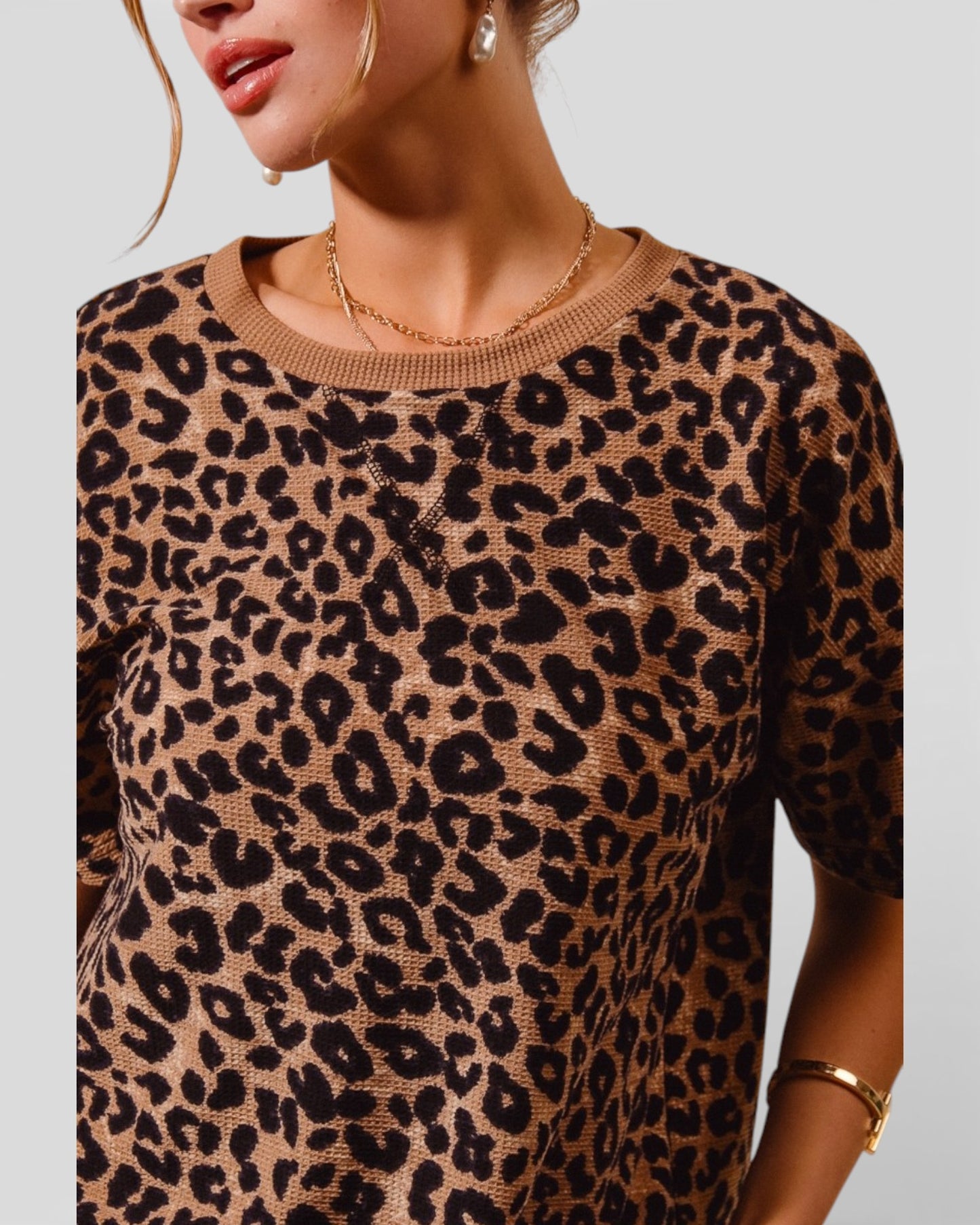 Leopard print sweater worn by a person on a plain background
