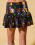Colorful sequin skirt with purple, green, and gold pattern on a beige background