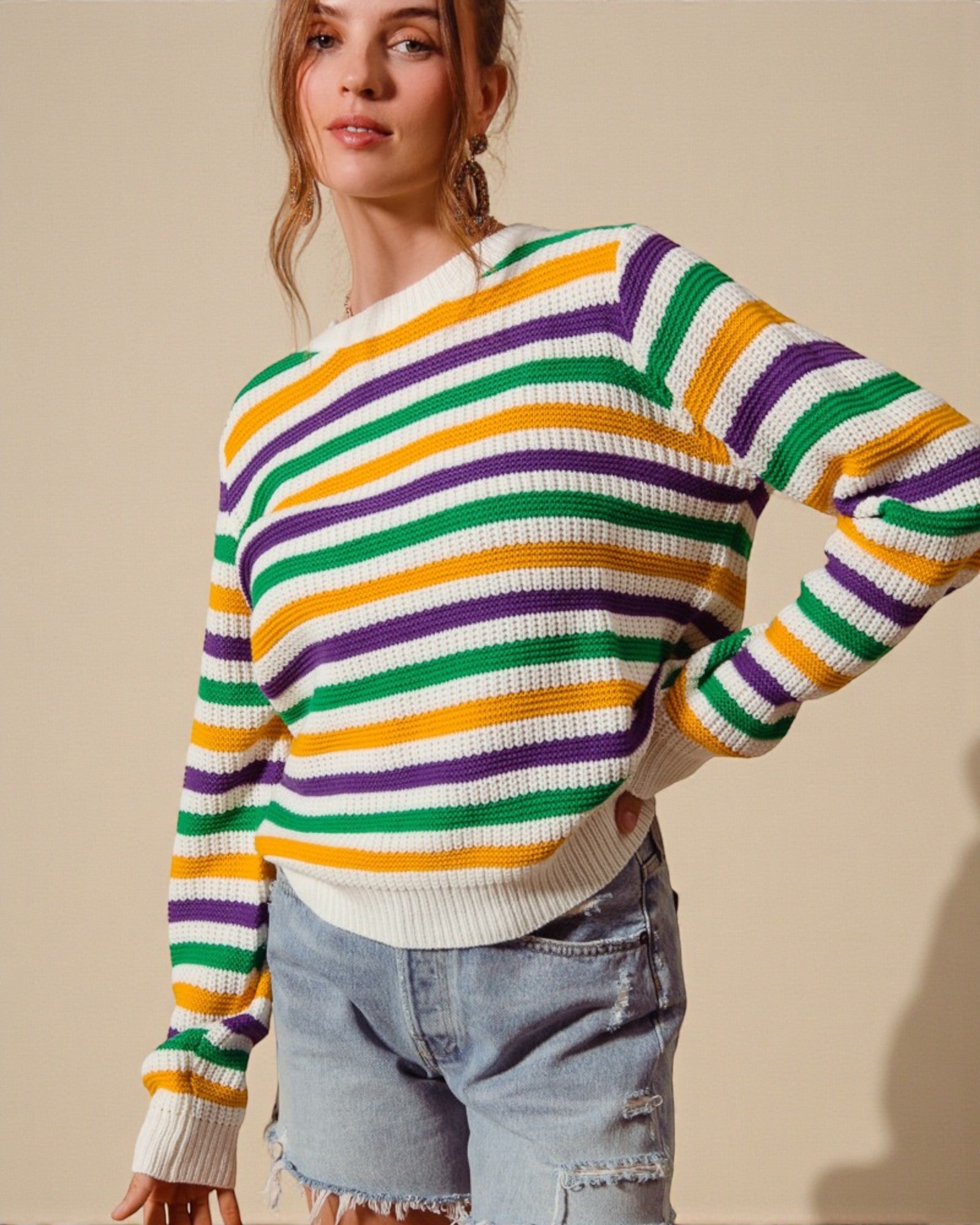 Woman wearing a colorful striped sweater against a beige background
